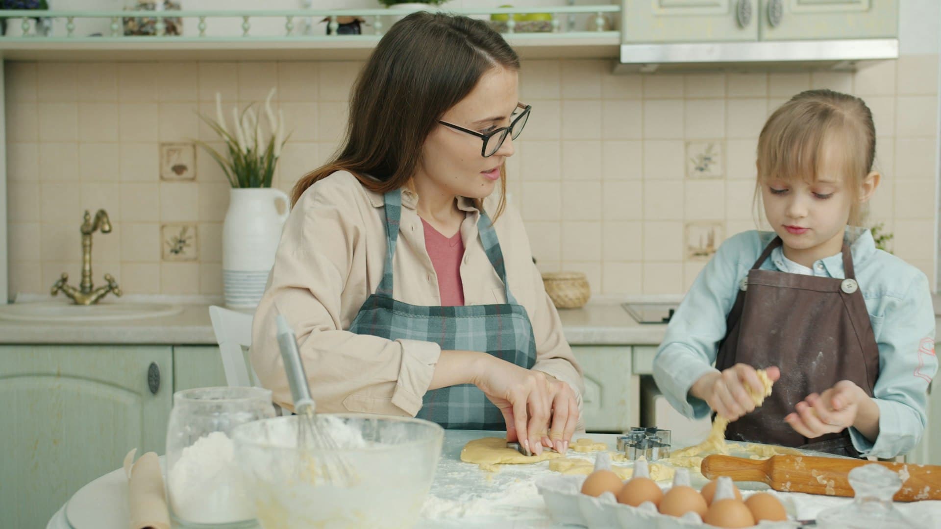 A parent and child cooking together in a home kitchen